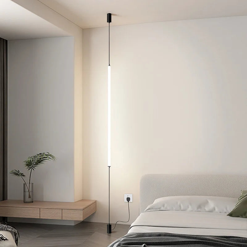 Modern bedroom with a bed, side table, and wall-mounted lamp.