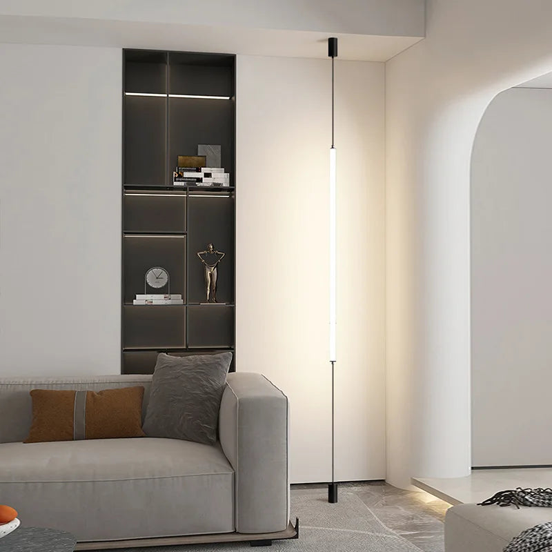 Modern living room with a gray sofa, floor lamp, and shelves.